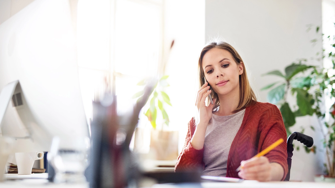 Frau im Rollstuhl am Arbeitsplatz