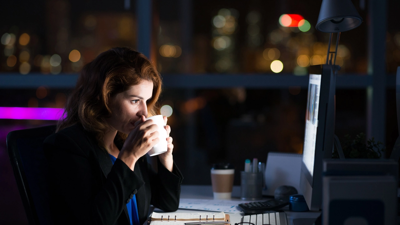 Eine Frau im Büro arbeitet Nachts am Computer