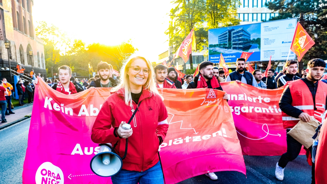 Die IG Metall Jugend zieht mit Fahnen und Megafon zur Kundgebung am Fairwandel-Aktionstag in Duisburg