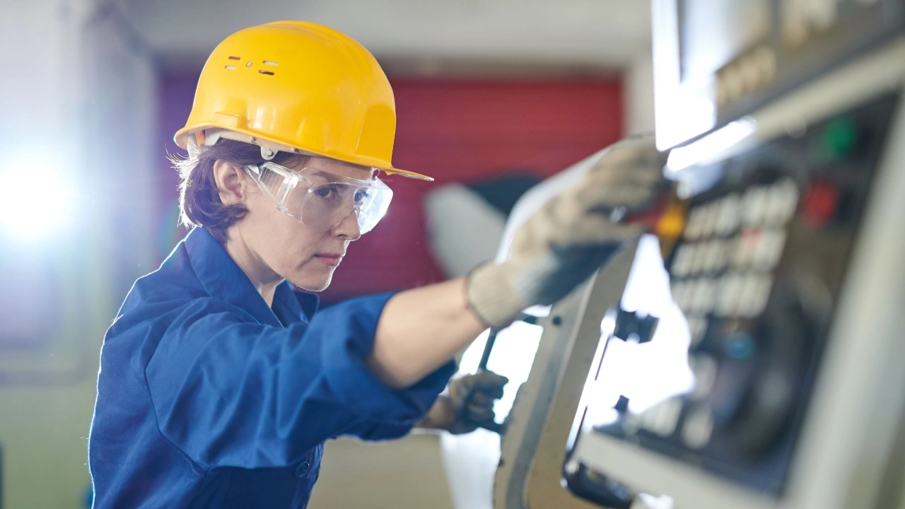 Arbeitnehmerin bedient Industriemaschine