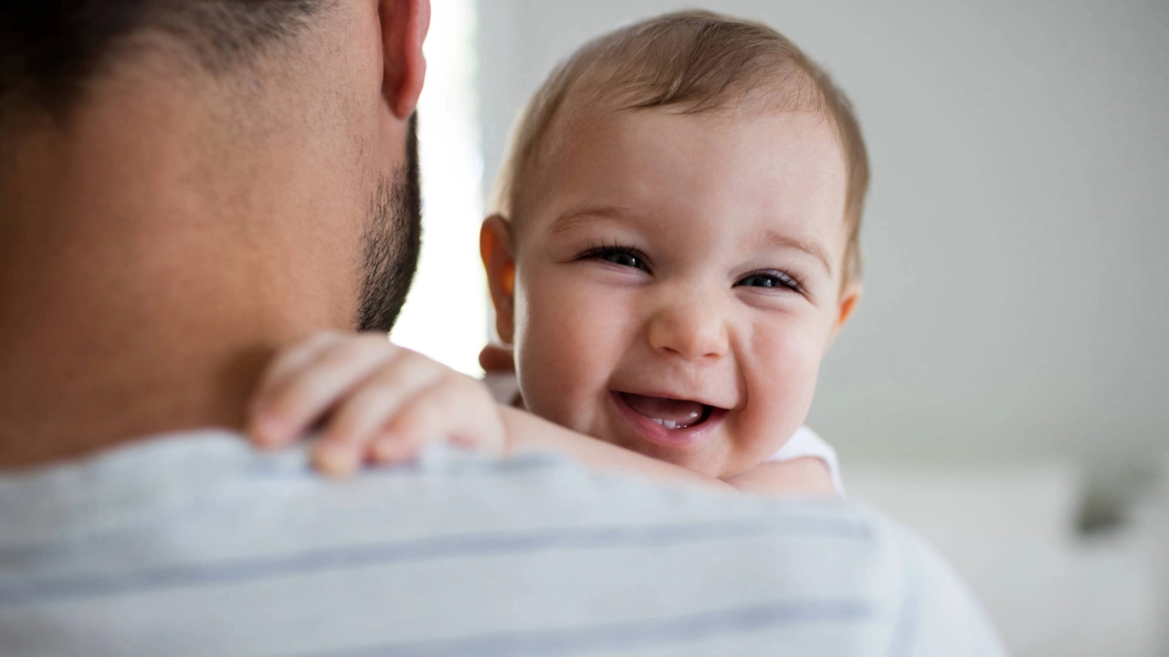 Ein lächelndes Baby auf dem Arm seines Vaters.