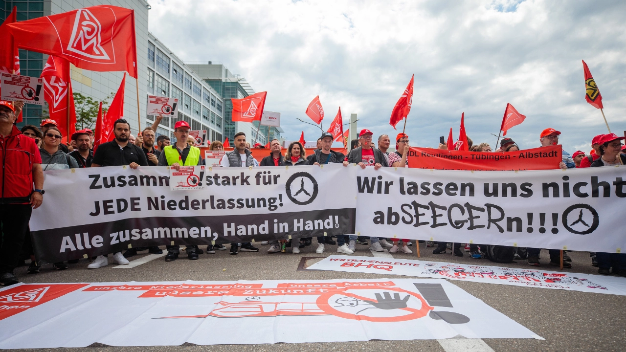 Beschäftigte der Mercedes-Niederlassungen in Sindelfingen stehen hinter Transparenten und protestieren bei einem Aktionstag