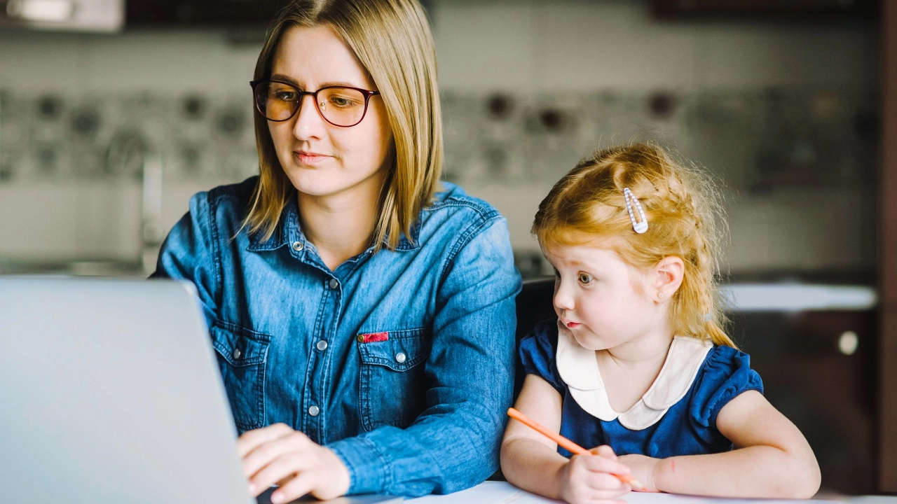 Mutter mit kleiner Tochter gemeinsam an einem Laptop