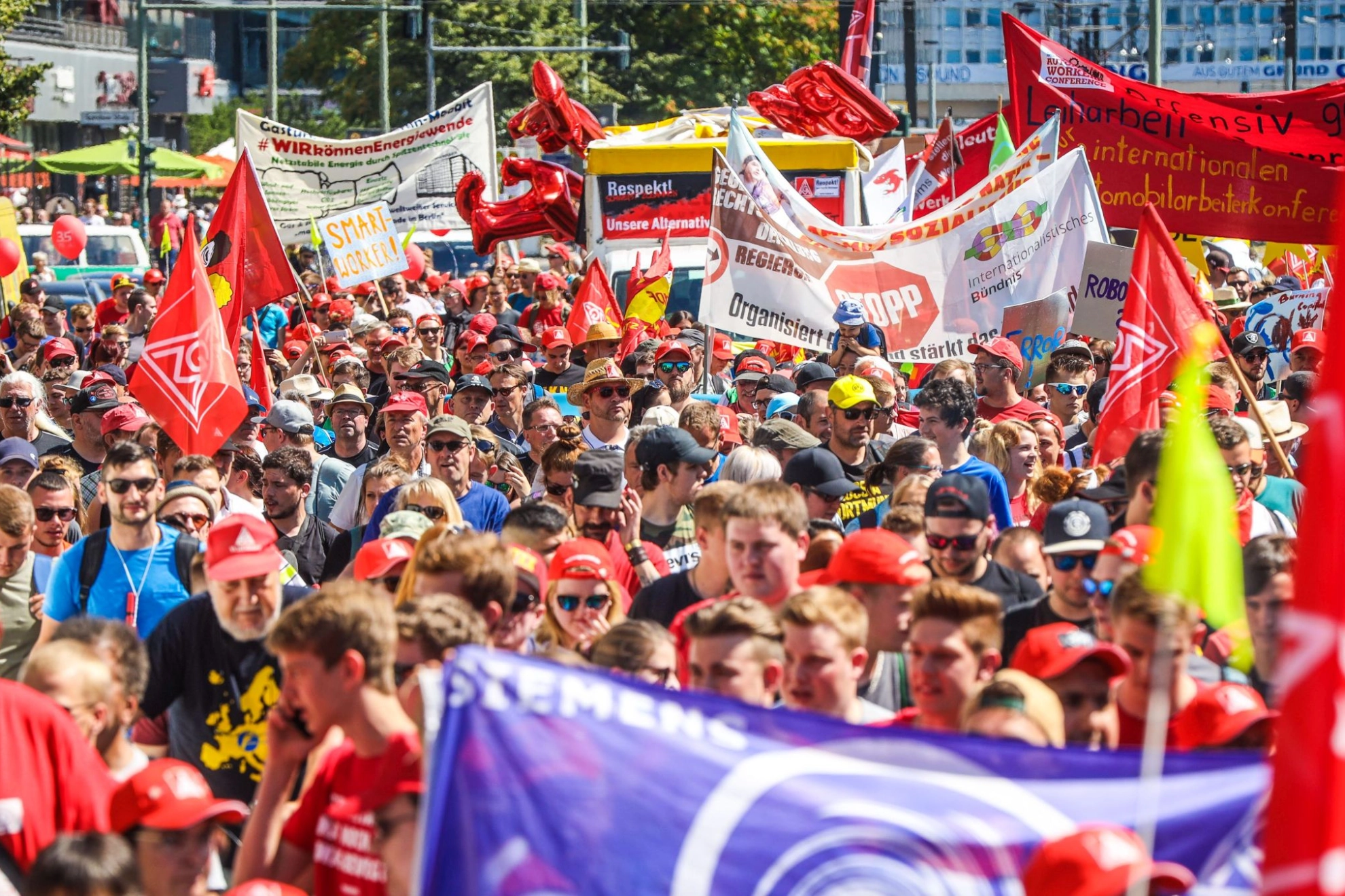 Metallerinnen und Metaller demonstrieren auf der FairWandel-Kundgebung mit verschiedenen Bannern