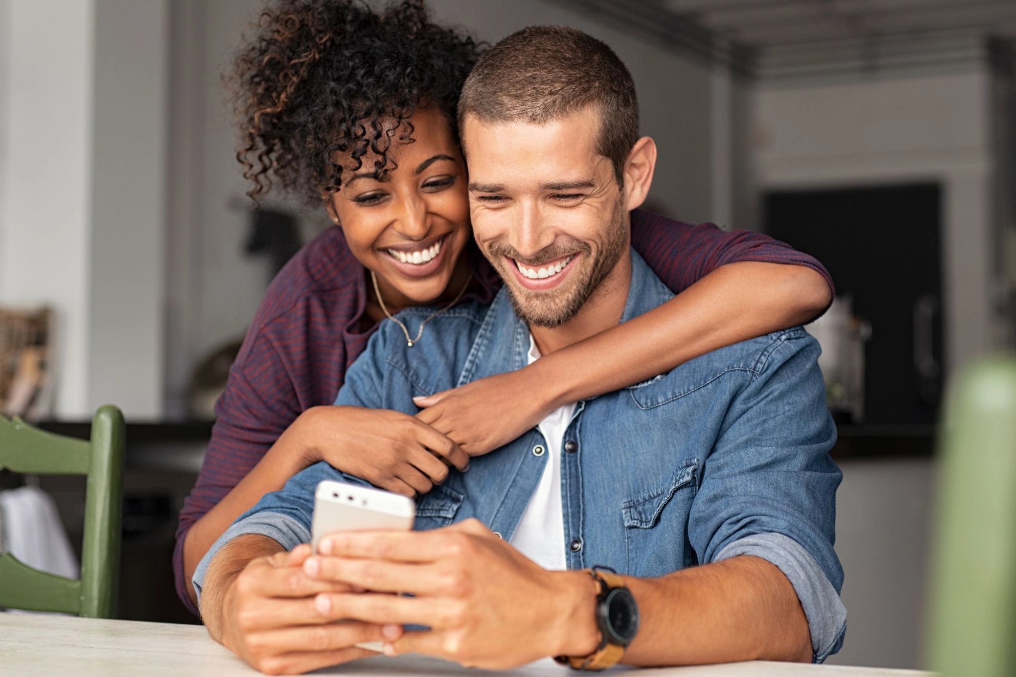 junges Paar sieht gemeinsam auf ein Smartphone
