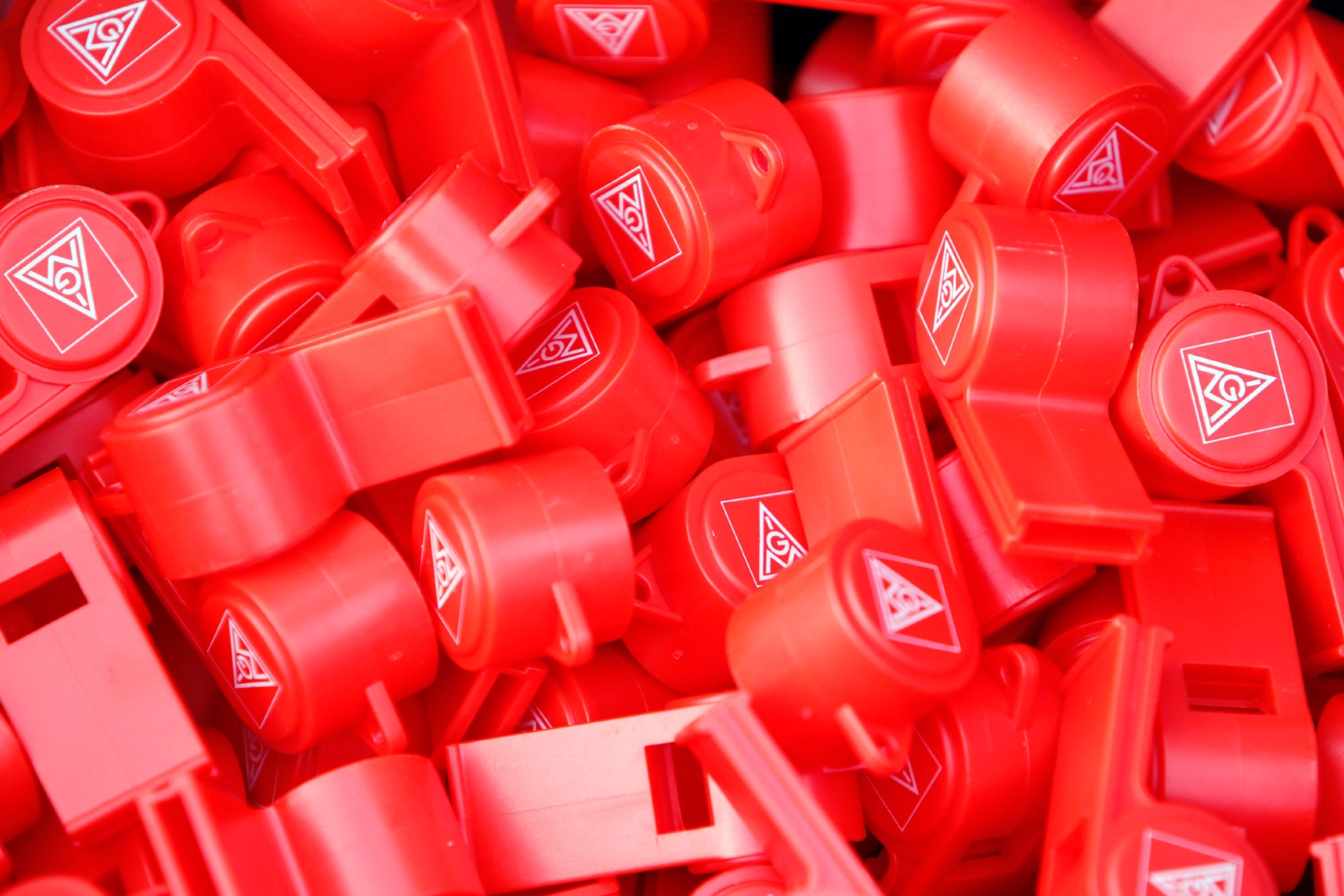 Viele rote Trillerpfeifen mit dem Logo der IG Metall.