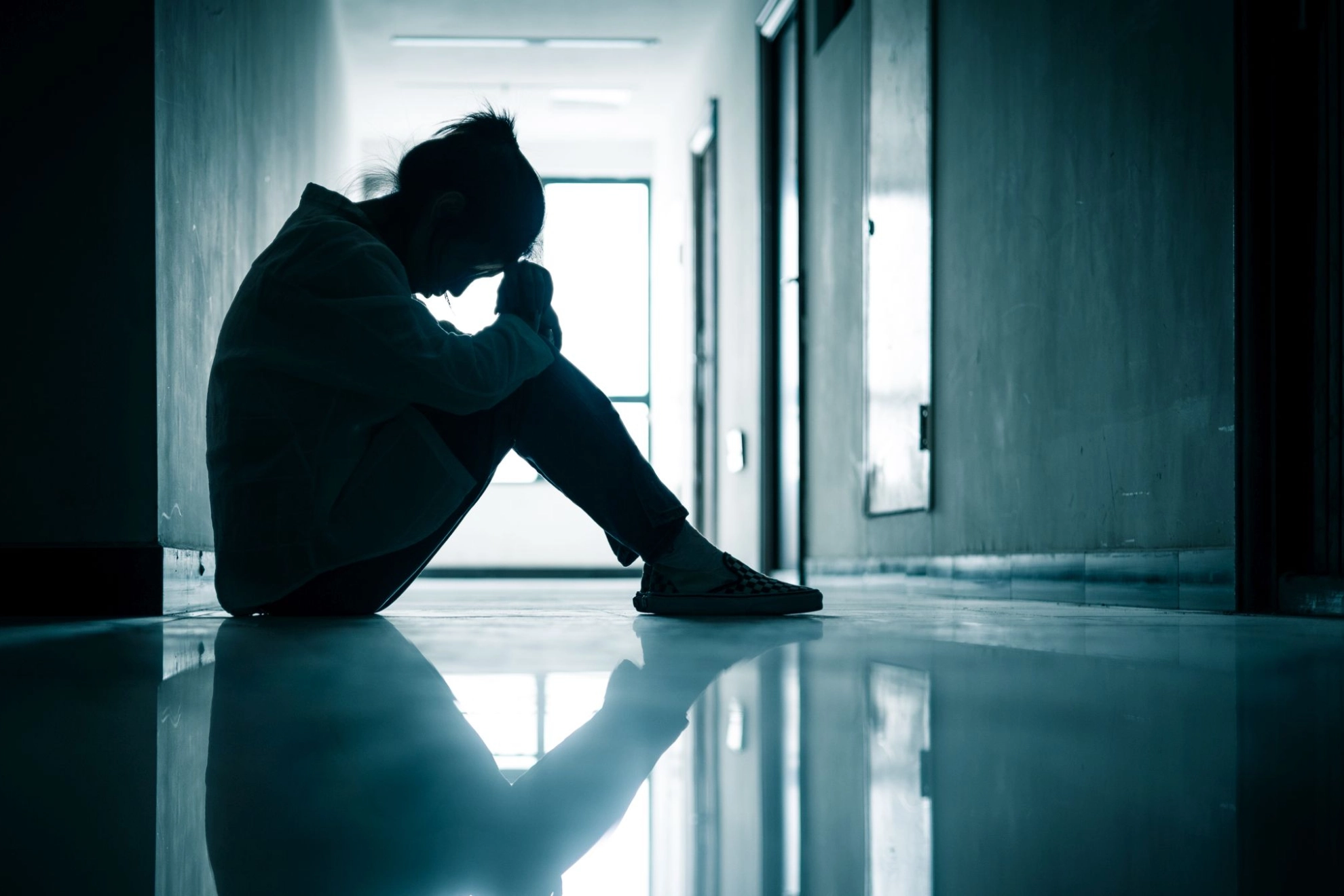 Einsame Frau sitzend auf Fußboden