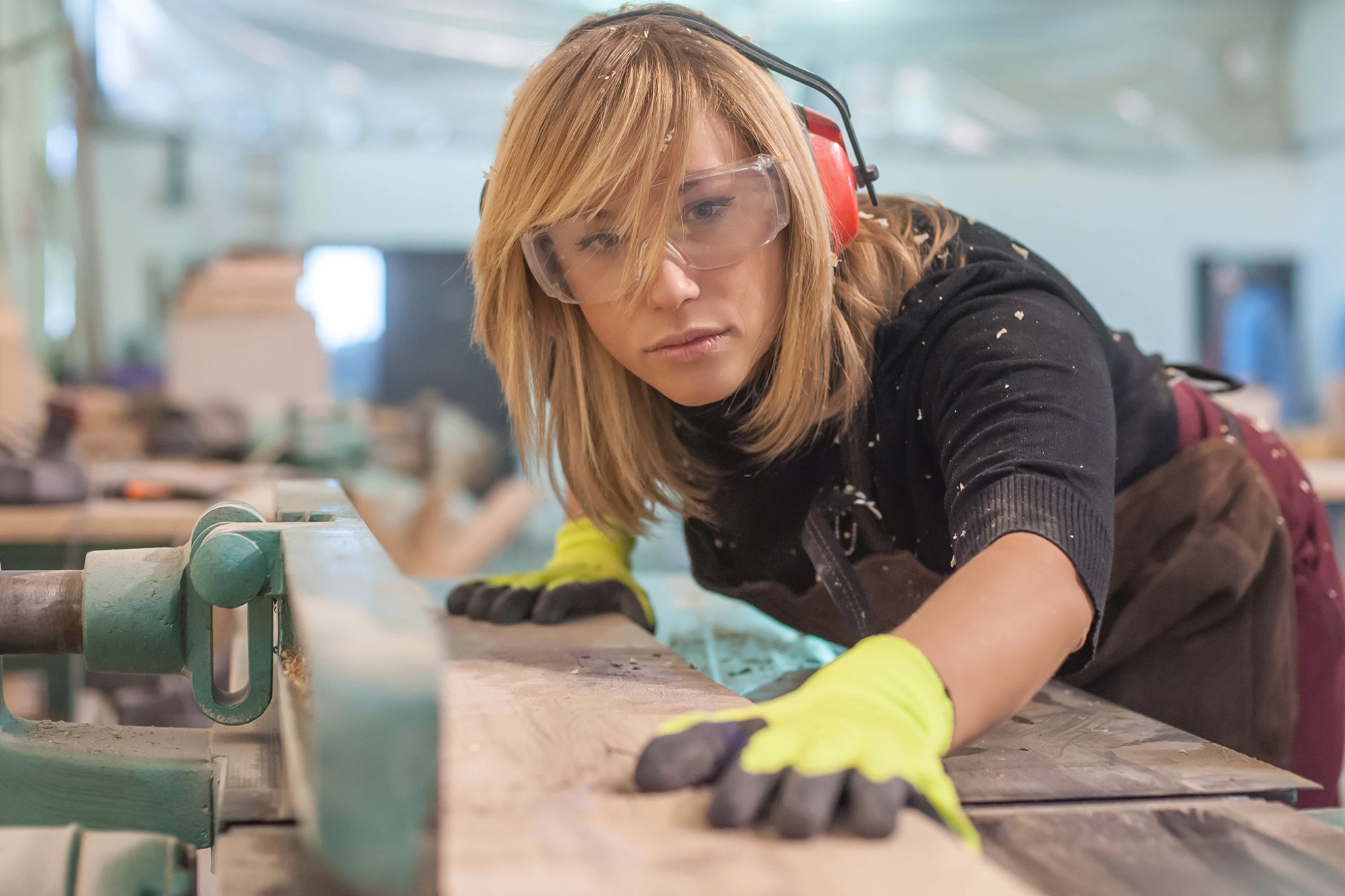 Schreinerin arbeitet an einer Maschine