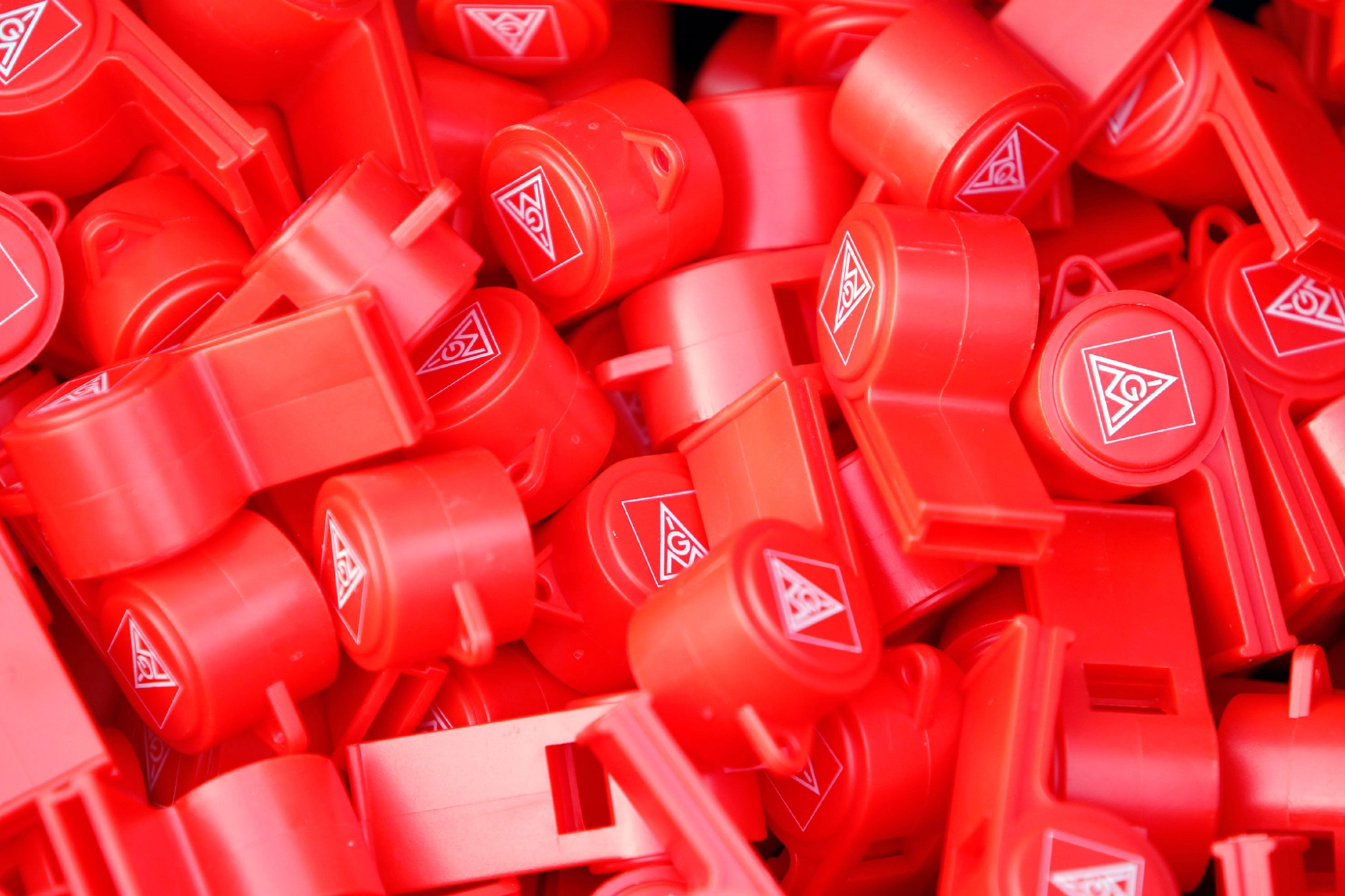 Viele rote Trillerpfeifen mit dem Logo der IG Metall.