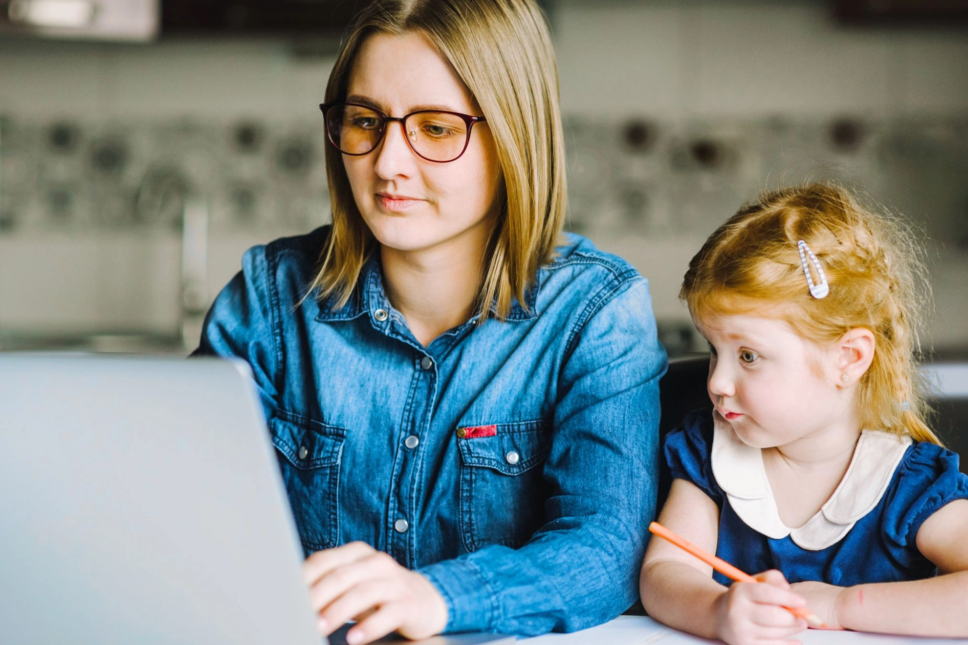 Mutter mit kleiner Tochter gemeinsam an einem Laptop