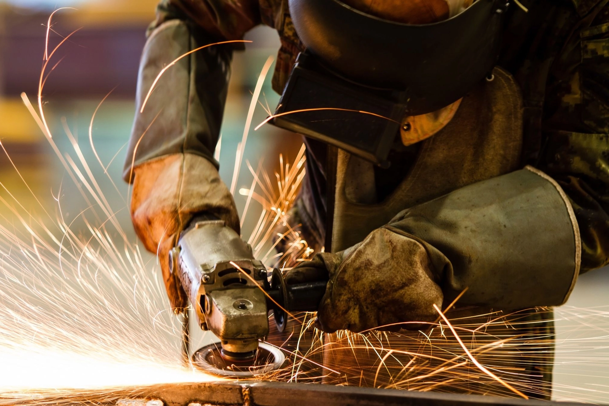 Ein Beschäftigter schleift Metall im Metallhandwerk