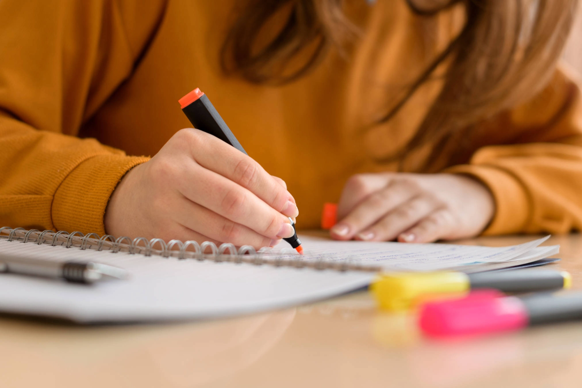 Jemand streicht mit einem Textmarker etwas auf einem Block an.