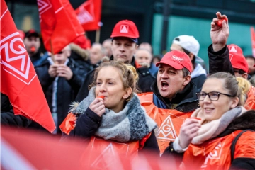 Zwei Frauen und zwei Männer mit Trillerpfeifen.